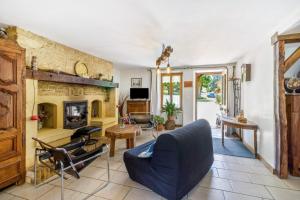 a living room with a blue couch and a fireplace at Gite Périgourdin - 2 Chambres in Saint-Geniès