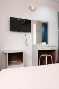 a white room with a table and a chair at Impress Star Hotel in Kampong Saleng