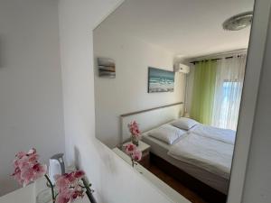 a small bedroom with a bed and a mirror at Guesthouse Villa Stanger in Lovran