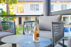 a bottle of wine sitting on a table with a wine glass at Ponciana Superior Guesthouse in Hartbeespoort