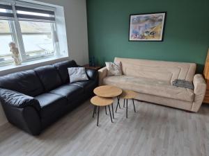 a living room with a couch and a table at Cosy apartment in Norðskála in Norðskáli