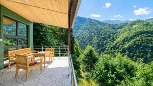 a balcony with a table and chairs and a view of the mountains at Vaio Resort in Keda in K'eda