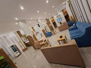 a living room with a blue couch and chairs at راحتي ستار للشقق المخدومة in Ukaz