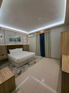 a bedroom with a white bed in a room at راحتي ستار للشقق المخدومة in Ukaz +17 photos