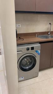 a washing machine in a kitchen next to a sink at Em banorama abrrtment hotel in Giza