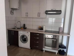 a kitchen with a stove and a washing machine at Prenoćište TG in Tomislavgrad +1 photo