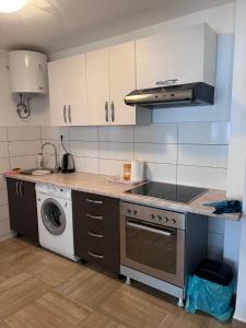 a kitchen with a stove and a washing machine at Prenoćište TG in Tomislavgrad