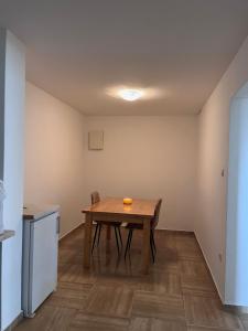 a dining room with a table and a kitchen at Prenoćište TG in Tomislavgrad