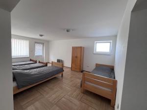 a bedroom with two beds and a wooden floor at Prenoćište TG in Tomislavgrad