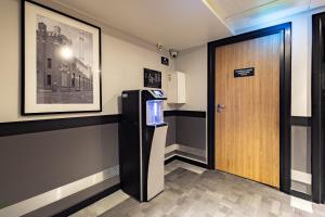 a room with a refrigerator and a wooden door at Campanile PRIME - Lodz in Łódź