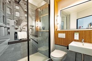 a bathroom with a toilet and a sink at Campanile PRIME - Lodz in Łódź