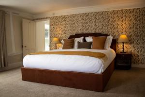 a bedroom with a large bed with white sheets at The Marlborough Inn in Marlborough
