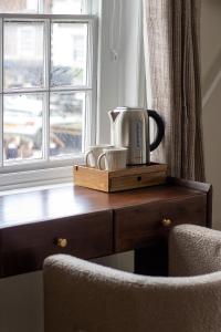 a coffee maker sitting on a wooden table next to a window at The Marlborough Inn in Marlborough