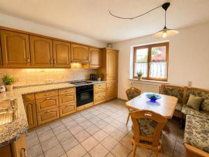 a kitchen with wooden cabinets and a wooden table at Ferienhaus Kenzenkopf in Halblech
