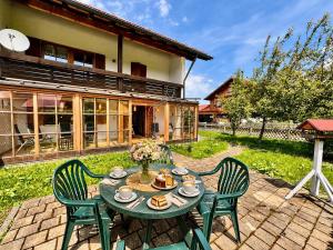a patio with a table and chairs in front of a house at Ferienhaus Kenzenkopf in Halblech