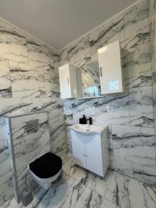 a bathroom with a toilet and a sink at Ionela in Năvodari +16 photos