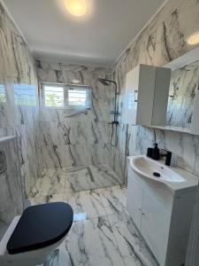 a marble bathroom with a sink and a toilet at Ionela in Năvodari