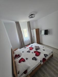 a bedroom with a bed with red roses on it at Ionela in Năvodari