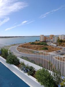 a balcony with a white fence and flowers at Home2830 in Barreiro