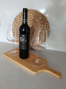 a bottle of wine and two glasses on a wooden board at Home2830 in Barreiro