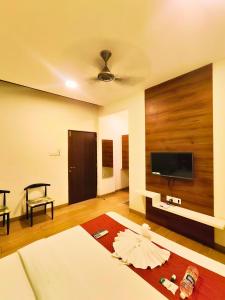 a living room with a flat screen tv on the wall at Fortune Resort in Alībāg