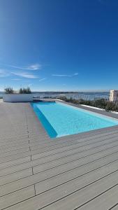 a swimming pool on a deck with the ocean in the background at Home2830 in Barreiro