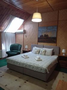a bedroom with a bed and a green chair at Zakarpatska Kolyba in Odesa