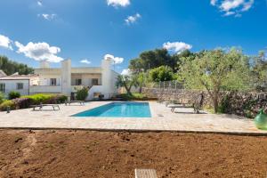 a villa with a swimming pool in front of a house at Villa Montevicoli in Ceglie Messapica