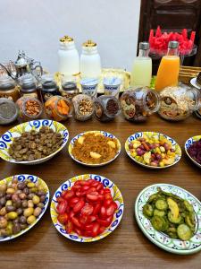 a wooden table with plates of food on it at Riad Boutique Baba in Rabat