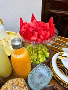 a table with a bowl of watermelon and a plate of fruit at Riad Boutique Baba in Rabat