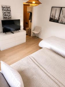 a bedroom with two beds and a flat screen tv at Mysig lägenhet i centrum in Västerås