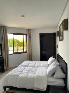 a large white bed in a bedroom with a window at Atlas Safari in Meknès +42 photos