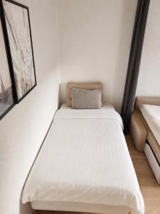 a bed in a small room with a white mattress at Mysig lägenhet i centrum in Västerås