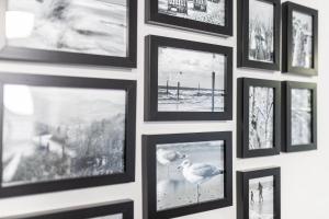 a wall of framed pictures on a wall at Rothen Huus in Norderney