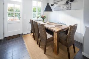 a dining room with a wooden table and chairs at Rothen Huus in Norderney