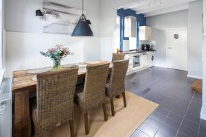 a kitchen with a wooden table with chairs and a vase of flowers at Rothen Huus in Norderney
