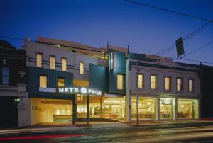 ein Gebäude an einer Straßenecke mit einem Geschäft in der Unterkunft Melbourne Metropole Central Official in Melbourne