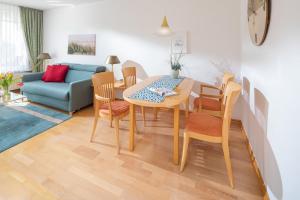 a living room with a table and chairs and a couch at Kleine Möwe 08 in Norderney