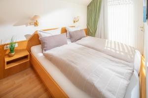 a bedroom with a bed with a white comforter at Kleine Möwe 08 in Norderney +6 photos