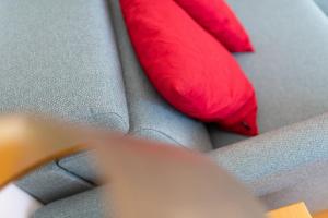two red pillows sitting on top of a couch at Kleine Möwe 08 in Norderney