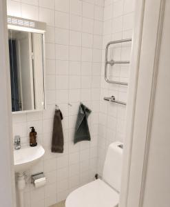 a white bathroom with a toilet and a sink at Mysig lägenhet i centrum in Västerås