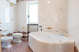 a bathroom with a tub and a toilet and a sink at Villa Montevicoli in Ceglie Messapica +26 photos