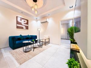 a living room with a blue couch and a table at HOMETEL An Nahdah in Jeddah