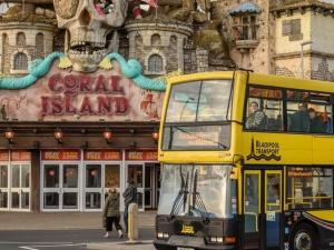 a yellow double decker bus parked in front of a building at Las Palmas Hotel by the Sea in Blackpool
