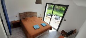 a bedroom with a bed with two blue pillows on it at Maison GINKGO in Hourtin +7 photos