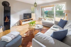 a living room with a couch and a tv at Mühlenloft in Norderney