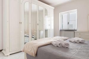 a white bedroom with a bed with towels on it at Villa Montevicoli in Ceglie Messapica