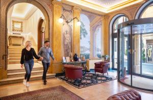a man and a woman walking through a lobby at Hotel Colomba d'Oro in Verona