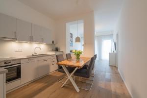 a kitchen with a wooden table and chairs in a kitchen at Meergenuss in Norderney