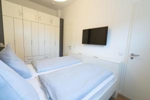 a bedroom with two beds and a flat screen tv at Meergenuss in Norderney +11 photos